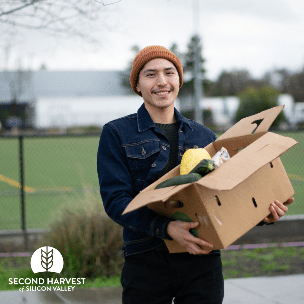 Moctezuma, college client, holding box of Second Harvest of Silicon Valley food. 